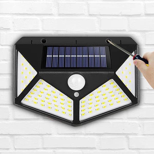 Manewise solar security light mounted on stable wall, being installed with screwdriver