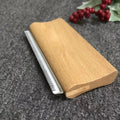 Manewise curry comb resting on fabric surface near red berries